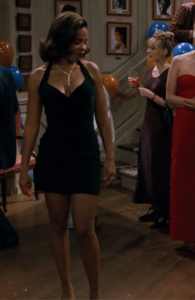 a woman in a short black dress standing next to other people