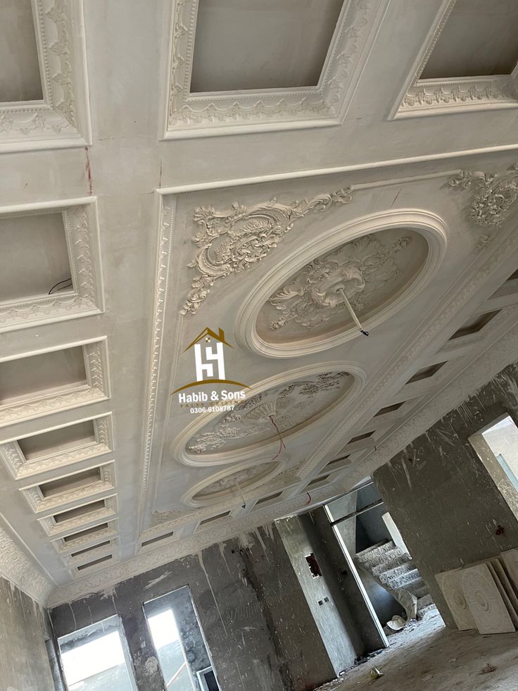 an unfinished room with white painted ceilings and plaster molding on the ceiling, looking up