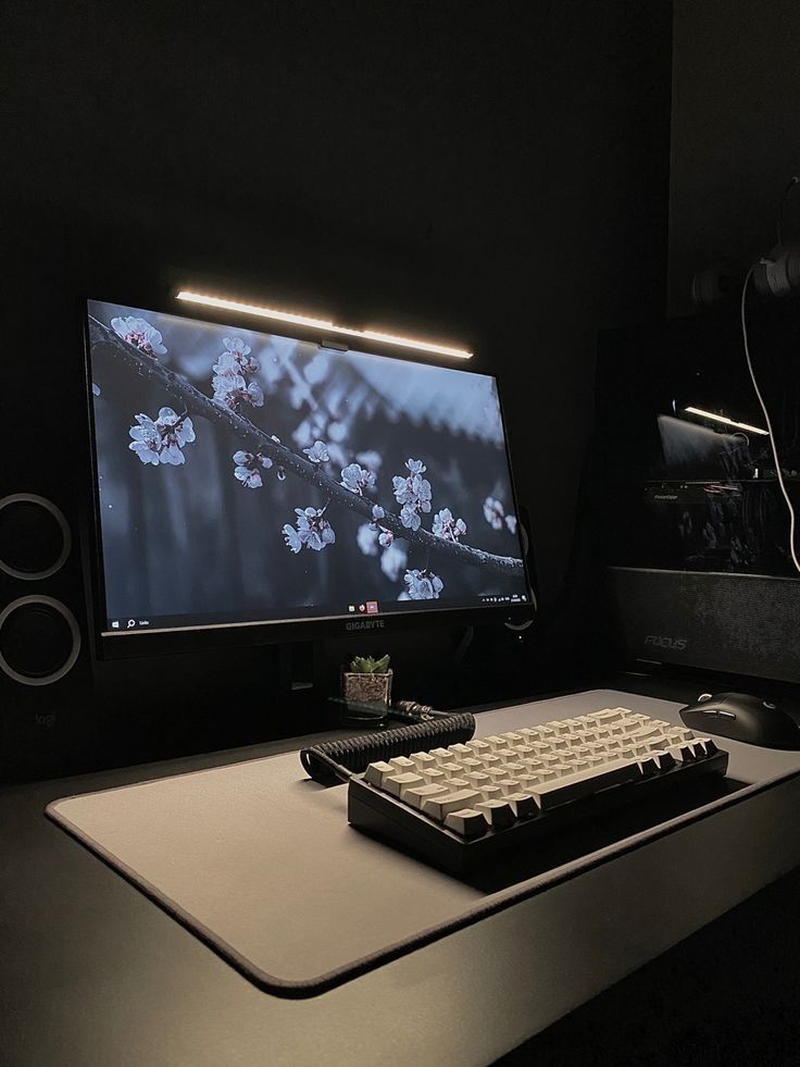 a computer monitor sitting on top of a desk next to a keyboard and mouse pad