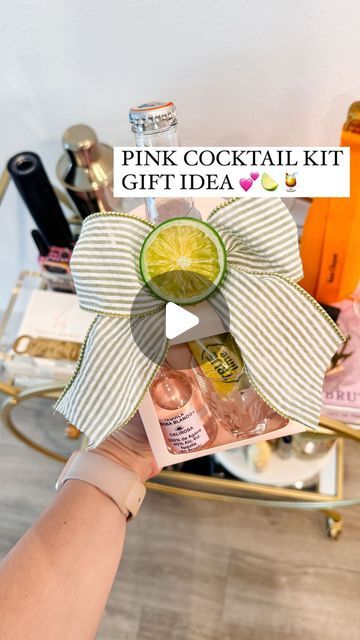 a person holding up a pink cocktail kit