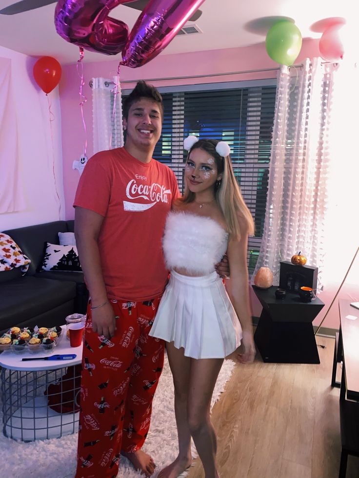 the man and woman are posing for a photo in their living room with balloons on the ceiling