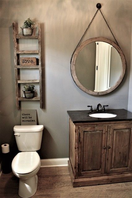 a bathroom with a toilet, sink and wooden cabinet in it's center area