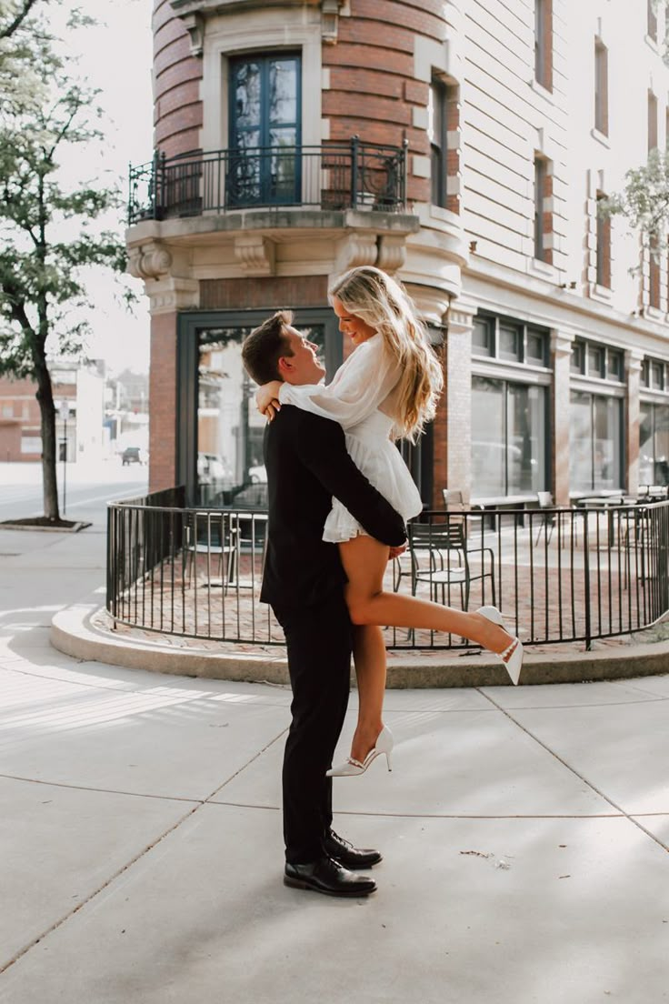 a man holding a woman on his back in front of a building