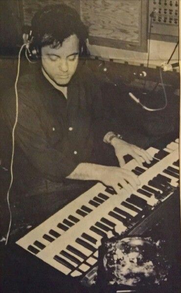 a man sitting at a keyboard with headphones on