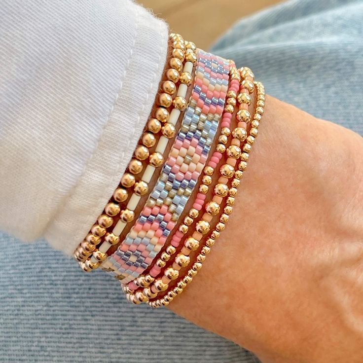 a close up of a person's arm wearing bracelets with beads on it