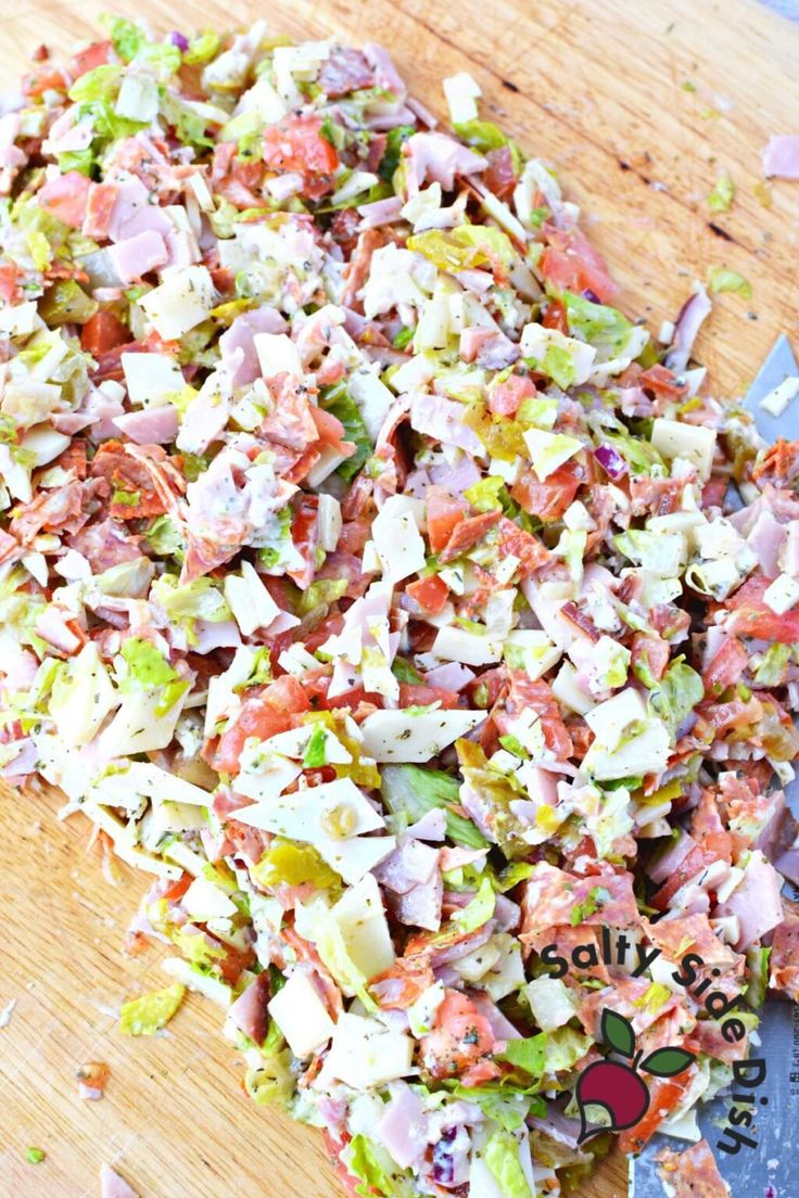 chopped up salad sitting on top of a wooden cutting board