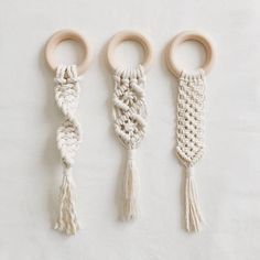 three wooden rings with tassels on them sitting next to each other in front of a white background