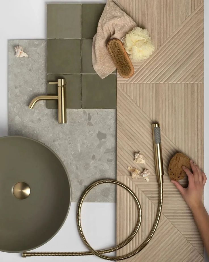 a bathroom with grey tiles and gold fixtures