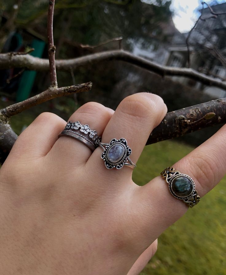 A person’s hand with multiple silver crystal rings on it. Silver Jewelry Aesthetic Rings Grunge, Black Jewellery Aesthetic, Dark Silver Rings, Earthy Rings Aesthetic, Layered Rings Silver Grunge, Fairygrunge Rings, Crystal Rings Silver, Dark Fairycore Jewelry, Rings Goblincore