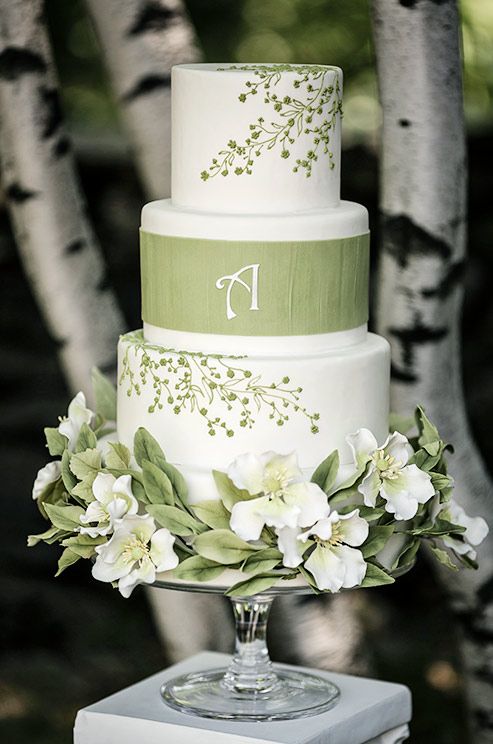 a three tiered wedding cake sitting on top of a white box next to a tree