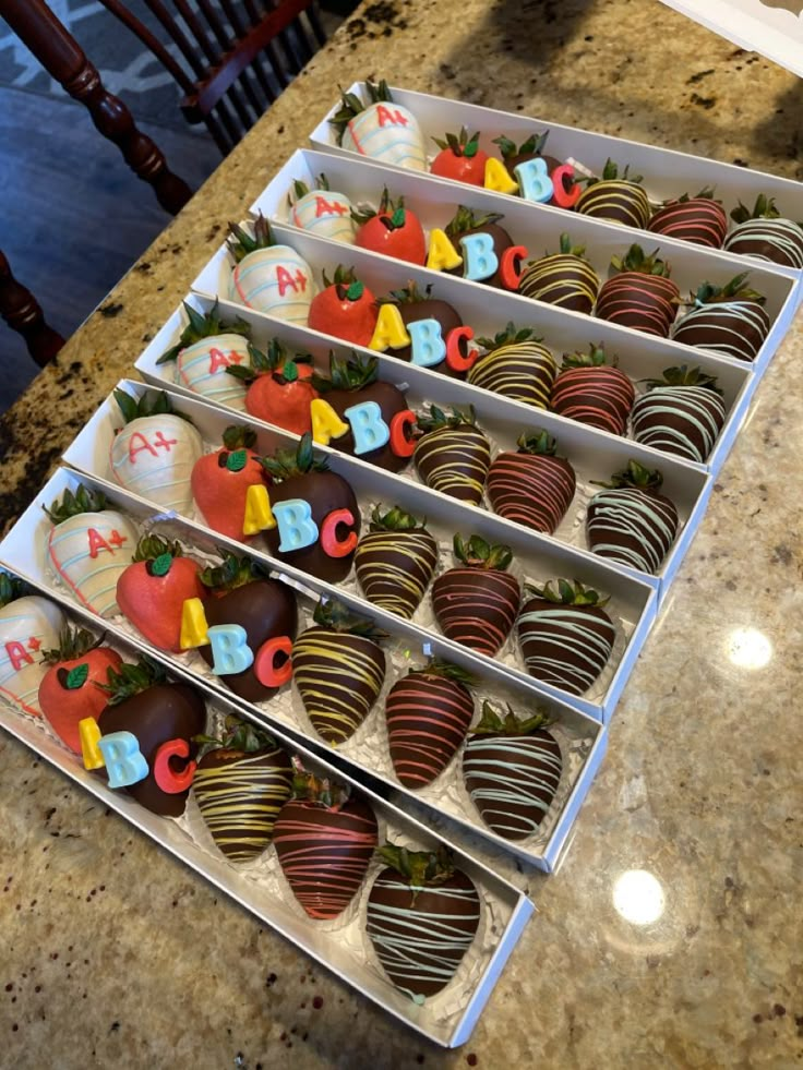 chocolate covered strawberries are arranged on trays with letters and numbers in the middle