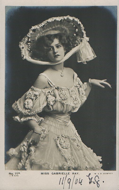 an old black and white photo of a woman wearing a hat with flowers on it