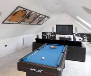 a pool table in the middle of a room with pictures on the wall and ceiling