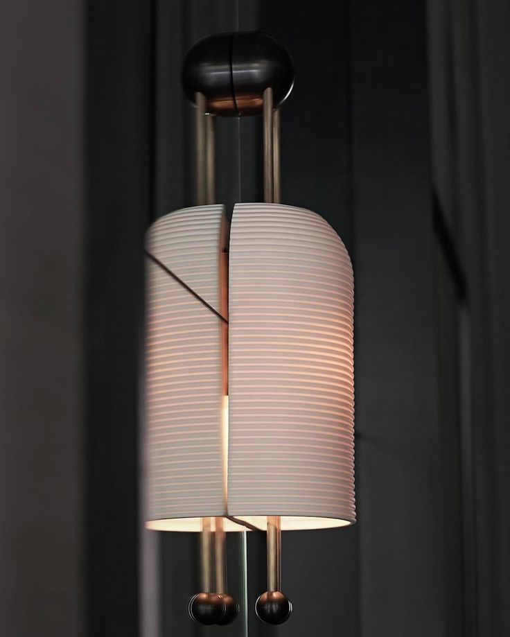 a lamp hanging from the ceiling in a room with dark walls and black flooring