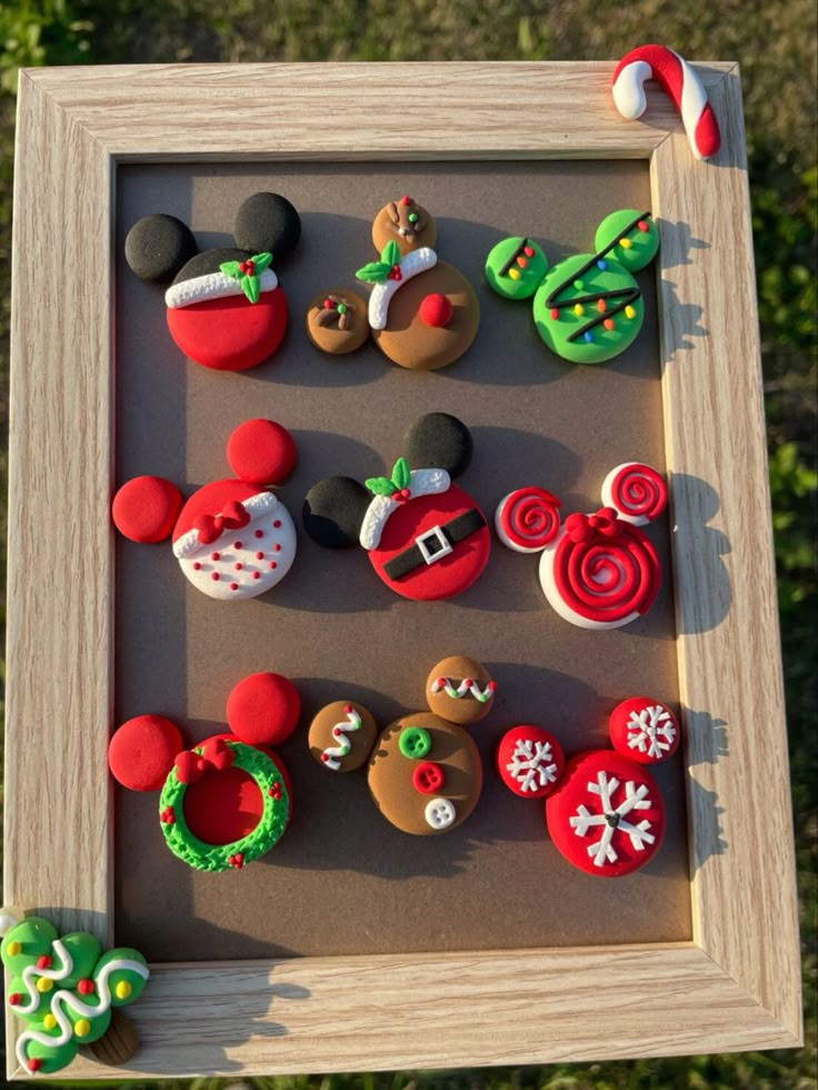 a shadow box filled with mickey mouse and christmas themed cookies on top of a table