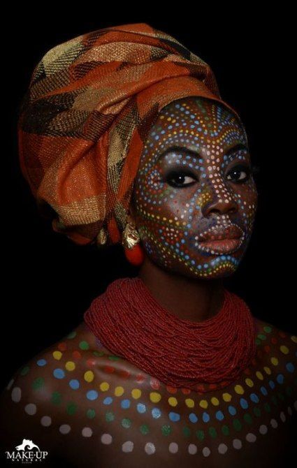 an african woman with painted face and headdress, wearing polka dots on her body