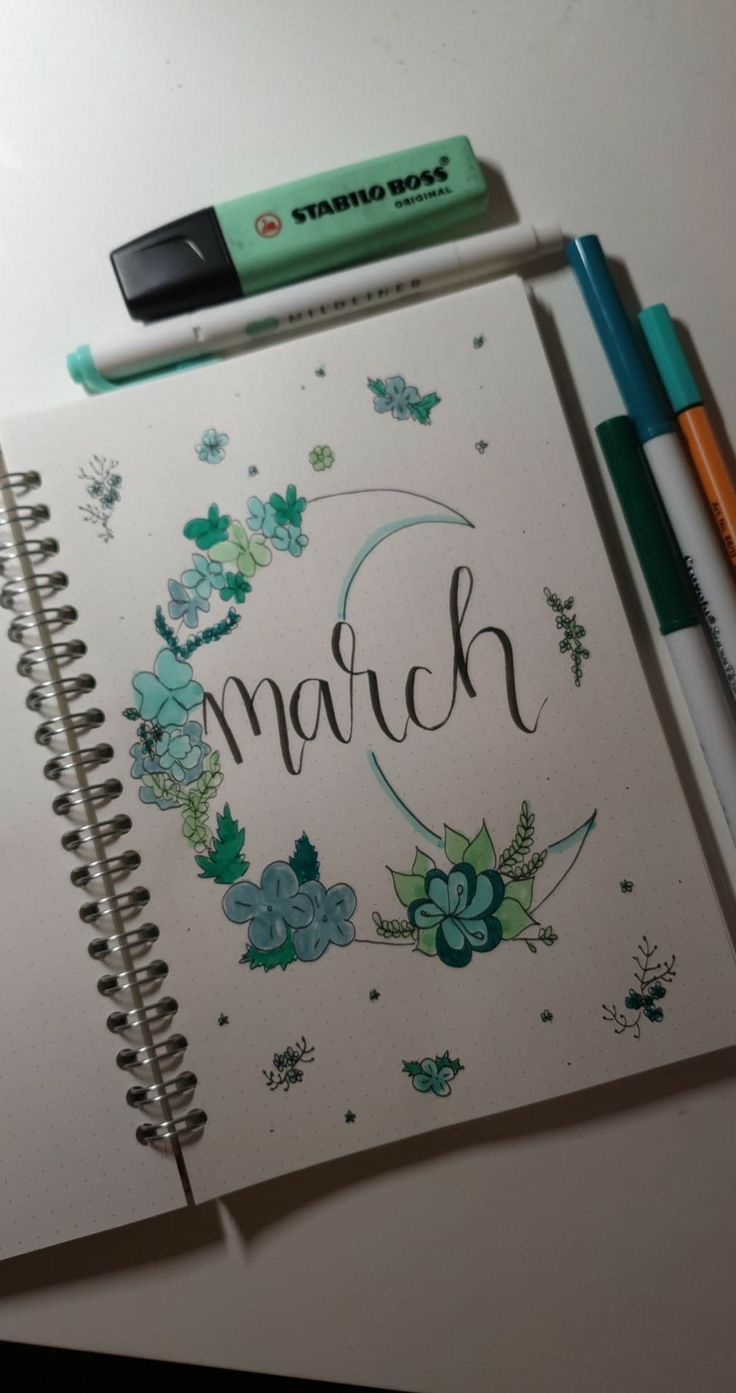 a notebook with the word march written on it next to two markers and a pencil