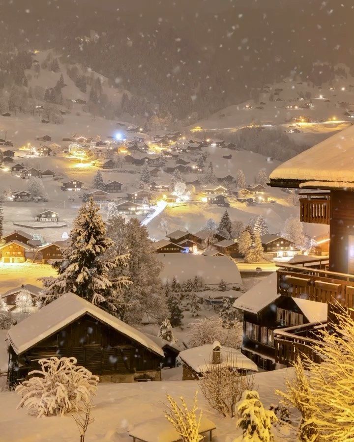 a snow covered town at night in the mountains