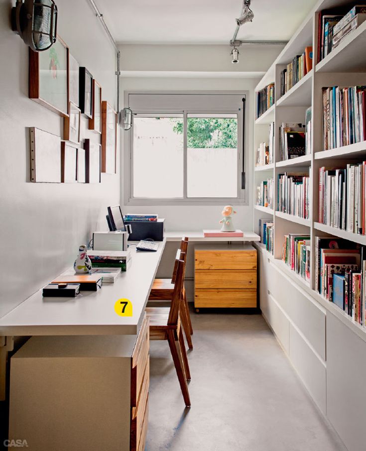 a room with many bookshelves and desks