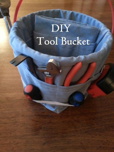 a bucket filled with tools on top of a wooden table