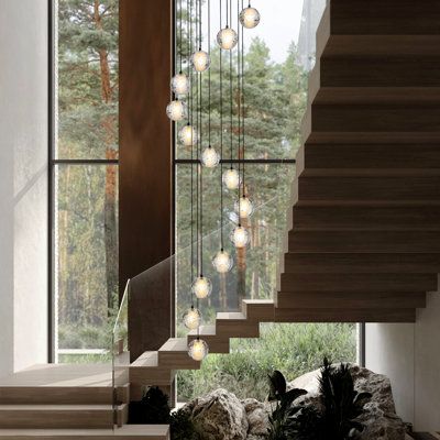 a staircase with glass balls hanging from it's side and some rocks on the ground