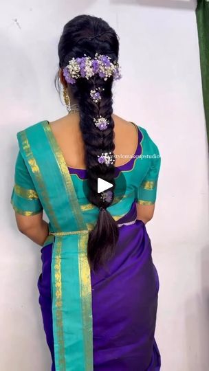 a woman with long hair in a purple and green sari