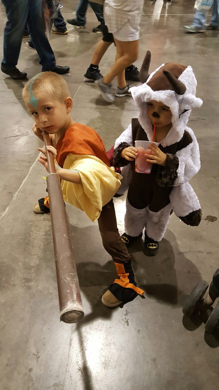 two young boys dressed up as animals and one is holding a stick in his hand