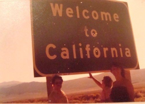 three people holding up a welcome to california sign