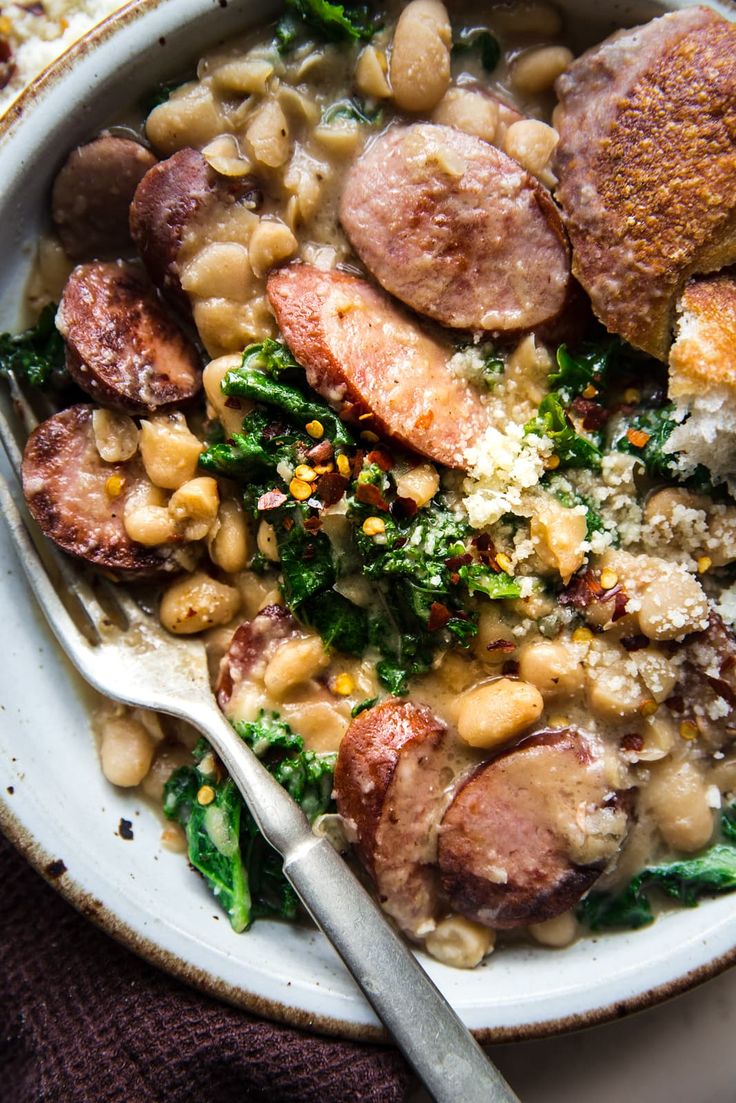 a white bowl filled with beans and sausage