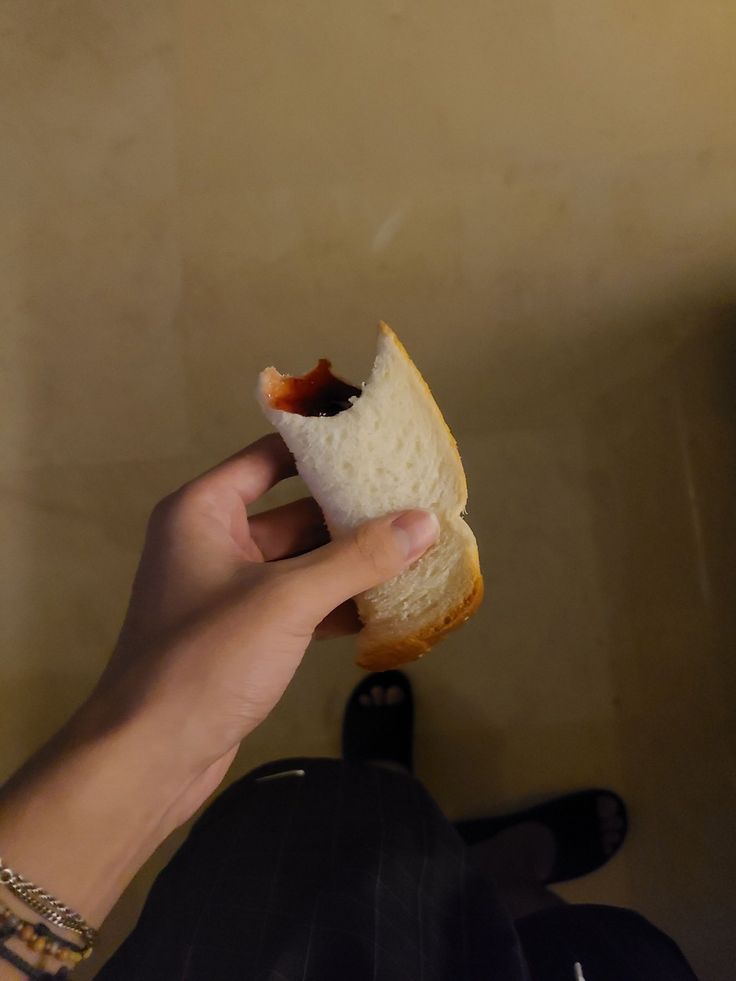 a person holding a half eaten sandwich in their hand