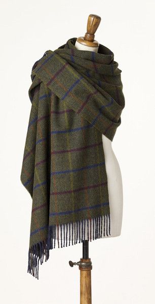 a green and blue plaid shawl draped over a mannequin's head