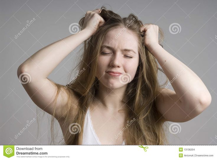 a young woman holding her hair in front of her head and looking at the camera