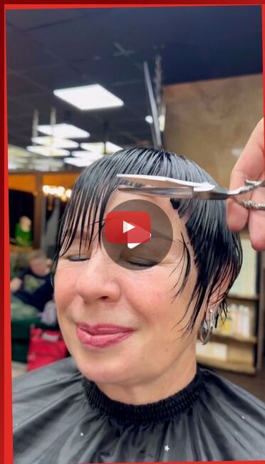 a woman getting her hair cut with scissors