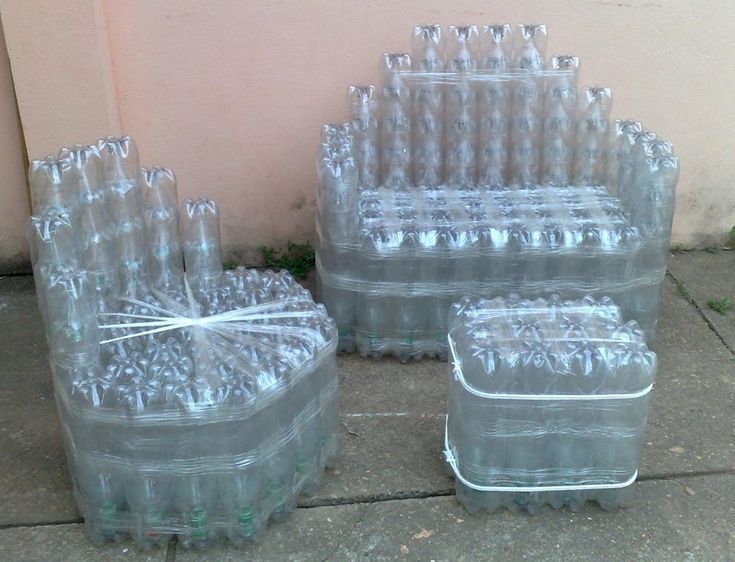 several plastic containers are sitting on the sidewalk next to each other, one is filled with empty water bottles