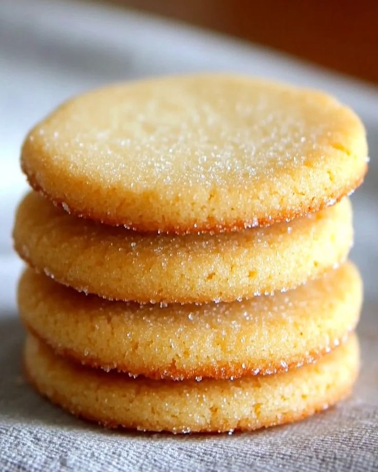 a stack of cookies sitting on top of a white cloth covered in powdered sugar