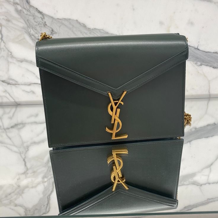 Cross Body Bag Ysl Clasp 100% Leather Width 8.8in/22.3cm Length 6in/15.2cm Depth 2in/5cm Approximate Strap Drop Length 24in/61cm Folded Curb-Chain Shoulder Strap Gold-Tone Metal Hardware Two Compartments, One Zip-Fastening Pocket, One Slip Pocket Burgundy Leather Lining Ysl Plaque Fastening Made In Italy Ysl Cassandra, Bags Ysl, Bag Ysl, Yves Saint Laurent Bags, Curb Chain, Metal Hardware, Cross Body Bag, Gucci Dionysus, Gold Tone Metal