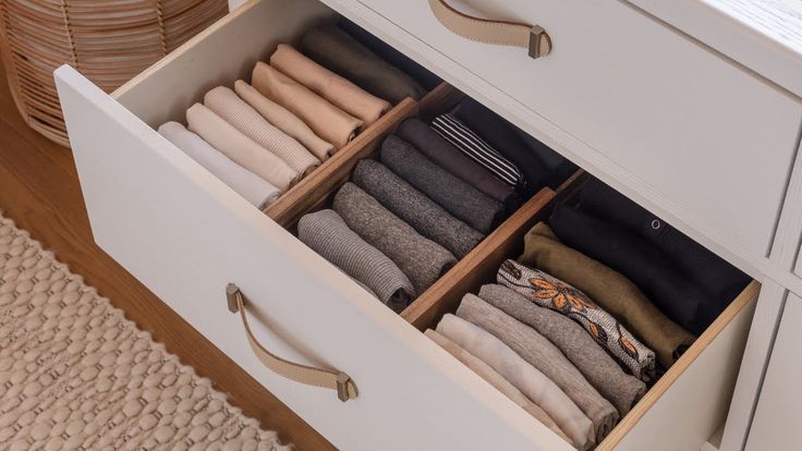 an open drawer with folded clothes in it