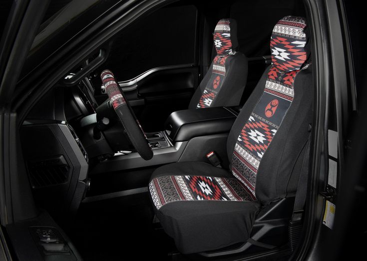 the interior of a car with two seats covered in black cloths and native designs