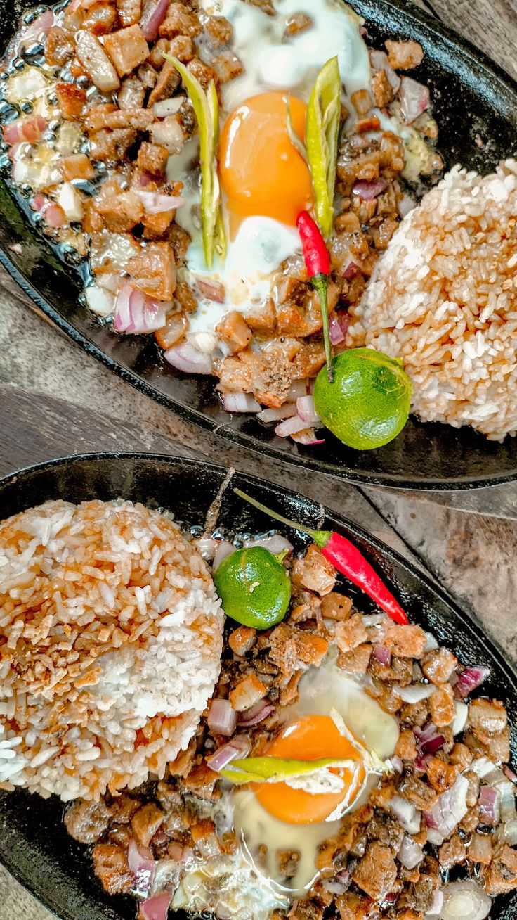 two plates filled with rice, meat and an egg on top of each other next to another plate