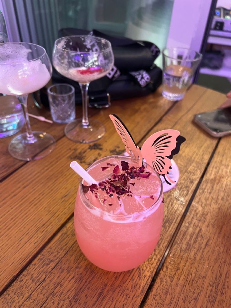 a pink drink sitting on top of a wooden table