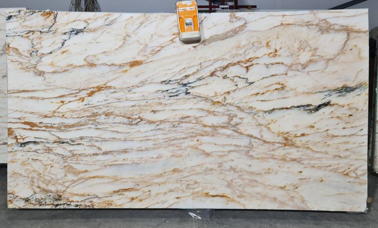 a marble counter top with white and gold veining on the edges, sitting in a warehouse