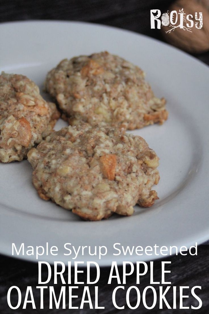 three oatmeal cookies on a plate with the title maple syrup sweetened dried apple oatmeal cookies