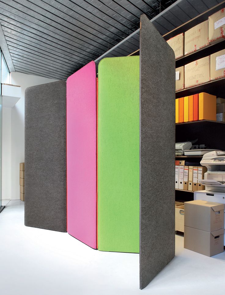 an office with three colored partitions in the center and several boxes on the other side