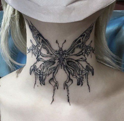 a woman's neck with a butterfly tattoo on her neck and the bottom part of her neck is covered in black ink