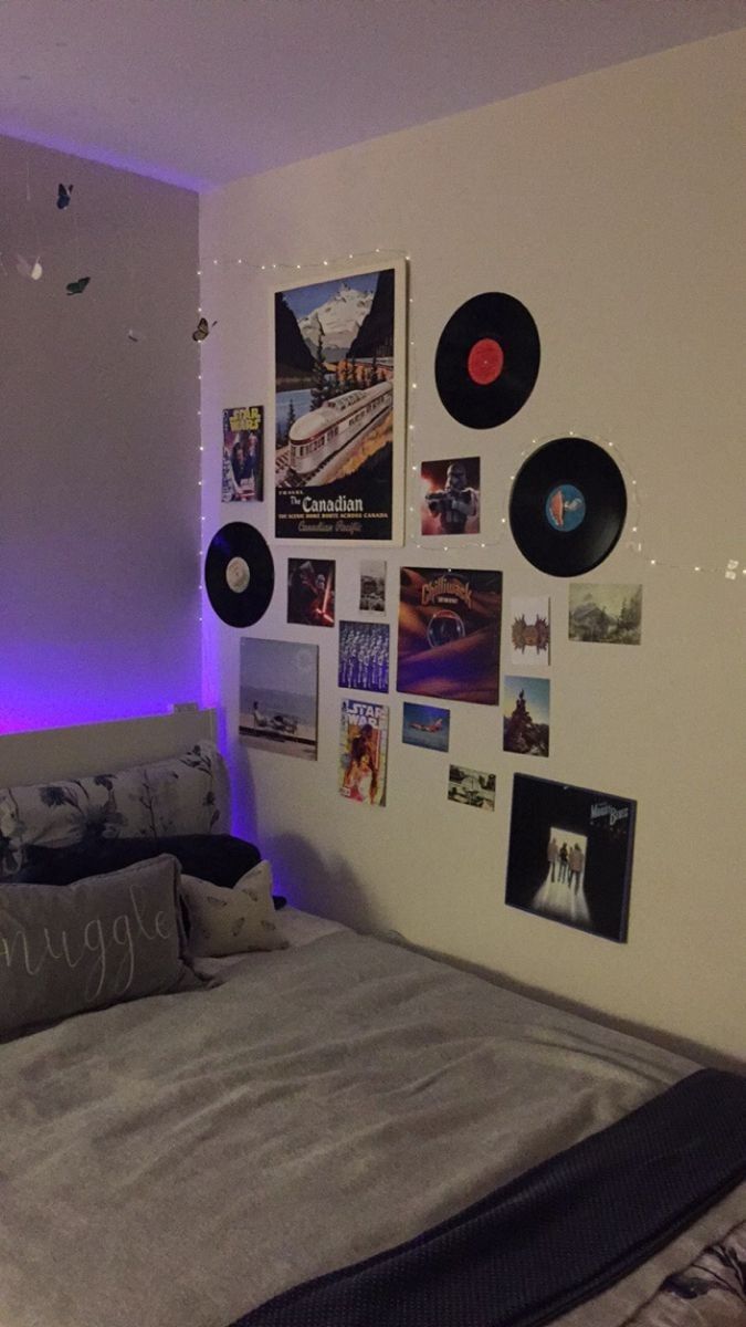 a bed room with a neatly made bed and lots of pictures on the wall