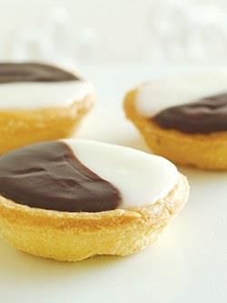 three cookies with chocolate icing and white frosting