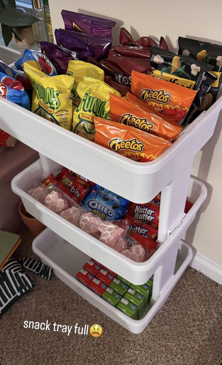 a refrigerator filled with lots of snacks and candy bar wrappers in it's bottom shelf