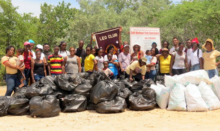 a group of people standing in front of bags of garbage