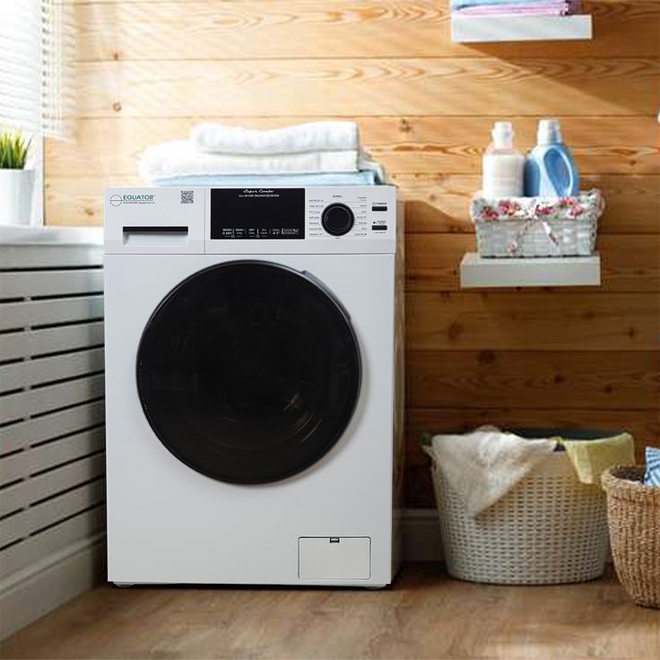 a white washer sitting next to a stack of towels on top of a wooden floor