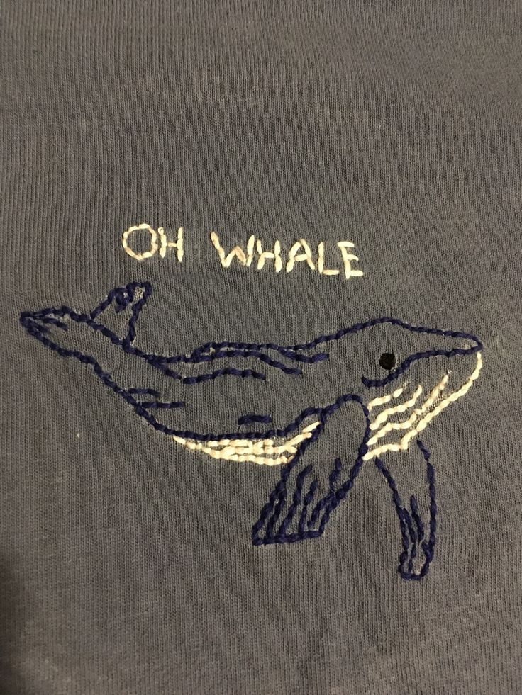 an embroidered t - shirt with the words oh whale on it